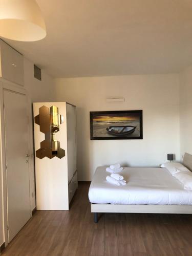 Una pequeña habitación con una cama y una nevera. en Casale 7- Navigli Cozy Studio perfect x2!, en Milán