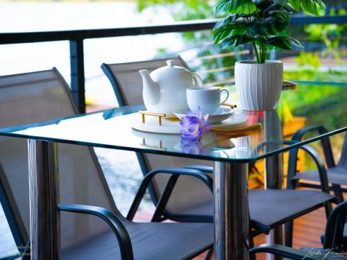 a glass table with a vase and cups on it at Bungalow 58 in Lake Bennett