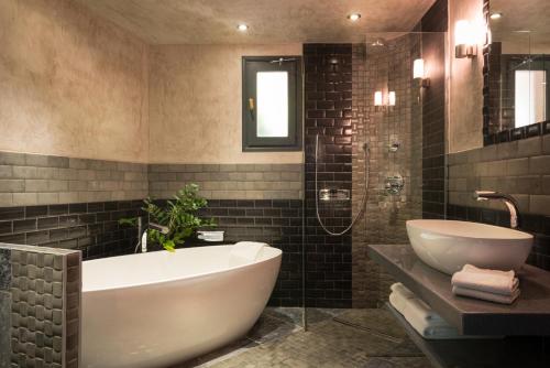a bathroom with a white tub and a sink at Hostellerie Les Gorges De Pennafort in Callas