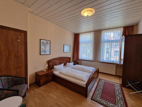 ein Schlafzimmer mit einem Bett und einem großen Fenster in der Unterkunft Hotel Haus Bremen garni in Bremen