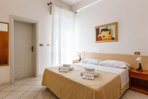a bedroom with a bed with two towels on it at Esperia Boutique Family Hotel in Cesenatico