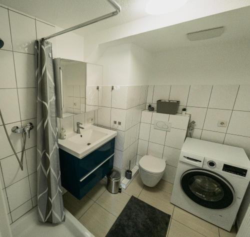 y baño con lavamanos y lavadora. en B&B Ferienwohnung mit bester Aussicht/Lage, en Wangen im Allgäu