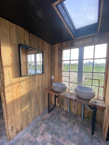 a bathroom with two sinks on a wooden wall at La Colmena Glamping in El Rosario