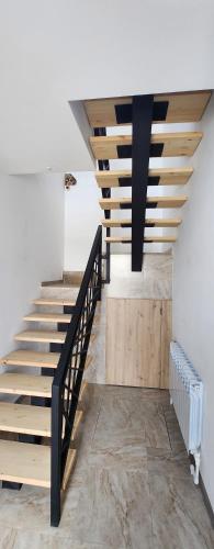 a staircase in a house with wooden stairs and a ceiling at Tatents Toon Guesthouse in Gyumri