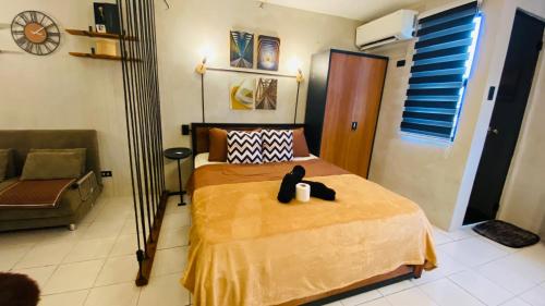 a bedroom with a bed with a black cat sitting on it at Casa Cabilao Staycation in Santa Rosa