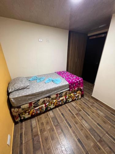 Cama pequeña en habitación con suelo de madera en Cómodo apartamento Piso #202 en Dosquebradas