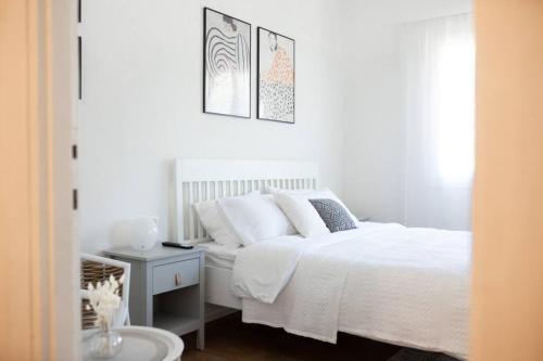 Dormitorio blanco con cama blanca y mesa en lovely apartment in Ra'anana en Ra‘ananna