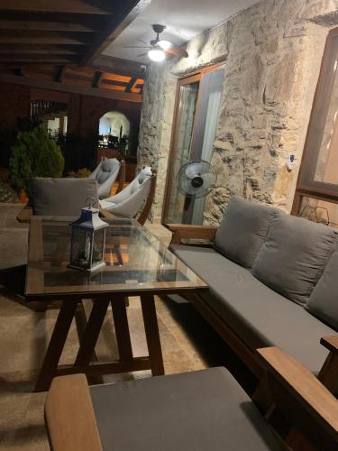 a living room with a couch and a glass table at Rustic Modern Patio Home With Shared Pool in Kırıkyayla