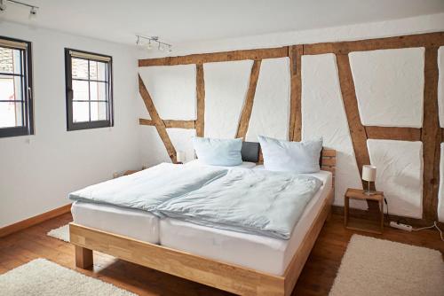 a bedroom with a large bed with white sheets and pillows at Mählich Haus in Manderscheid