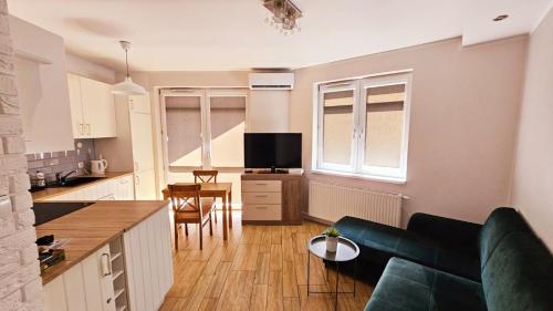 een keuken en een woonkamer met een bank en een tafel bij Apartament Młynarska in Piła
