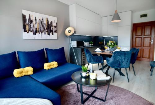 ein Wohnzimmer mit einem blauen Sofa und einem Tisch in der Unterkunft SuiteAngel - Luxury Design Condo with free garage in Budapest