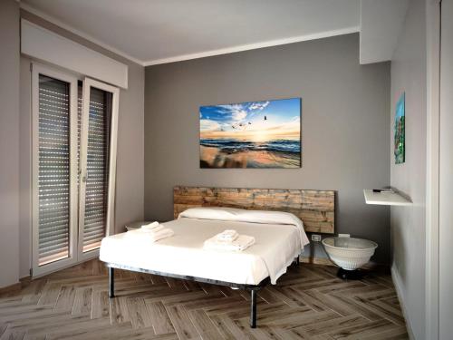 a bedroom with a bed and a painting on the wall at The House of the Waves in Brindisi