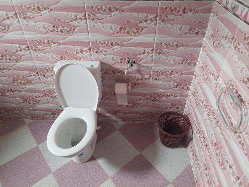 a bathroom with a toilet in a pink room at Comfort house 