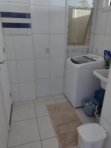 a bathroom with a washing machine and a sink at Quartos - Cíntia in Fortaleza