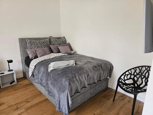 a bedroom with a bed and a chair at Casa Frida - Business flat near BER, kitchen, bathroom, balcony, workspace, 24" Monitor, Wifi, SmartTV, Netflix, car park in Berlin