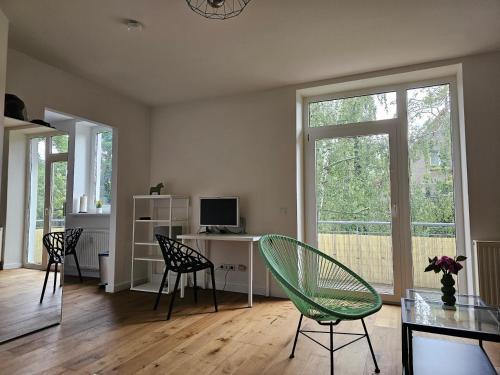 a living room with a table and chairs and a window at Casa Frida - Business flat near BER, kitchen, bathroom, balcony, workspace, 24" Monitor, Wifi, SmartTV, Netflix, car park in Berlin