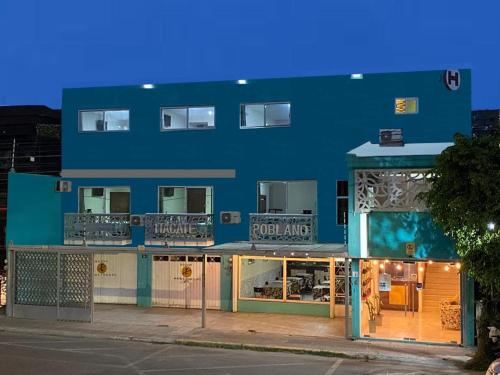um edifício azul com uma frente de loja com janelas em CORDIALITY INN em Puebla