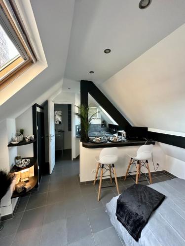 une chambre avec un lit et deux chaises dans une cuisine dans l'établissement Studio chaleureux hypercentre Amiens, à Amiens
