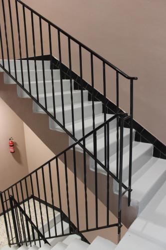 a staircase with black metal railings in a house at Les AGRIATES in Besançon
