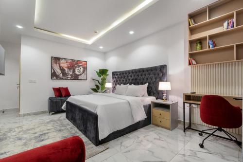 1 dormitorio con 1 cama grande y 1 silla roja en W16 Water Front Apartments en Lekki