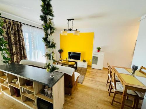 a living room with a table and a yellow wall at Apartament Sofia in Sibiu