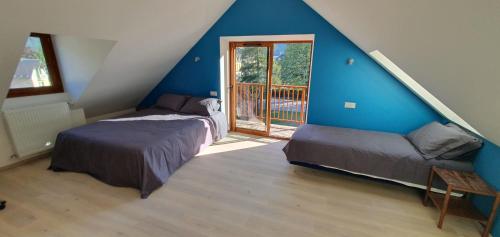 Dos camas en una habitación con paredes azules. en Maison de la Lionne, en Luchon