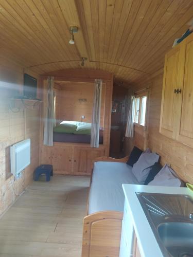 Habitación pequeña con cama en una casa de madera en Roulotte en Marnefer