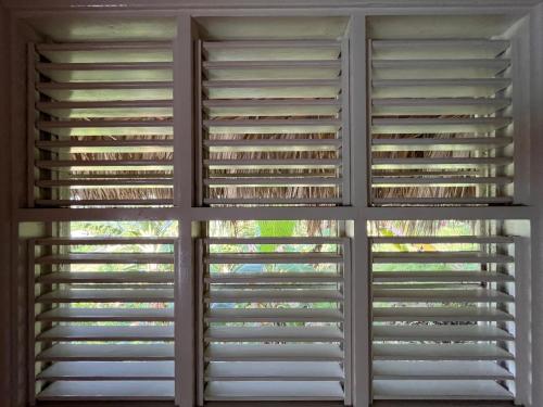 a room with plantation shutters on the windows at Casa bambu - charming villa in the heart of nature in El Limón