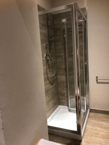 a shower with a glass door in a bathroom at Residenza Solferino in Cremona
