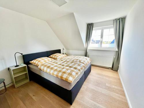 a bedroom with a bed and a large window at Luxuriöse Doppelhaushälfte am grünen Rande von Hamburg in Oststeinbek