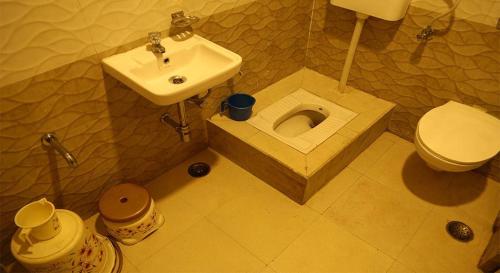 a bathroom with a toilet and a sink at KINGSWAY HOTEL AND RESTAURANT Ajmer Dargah 350 Meter in Ajmer