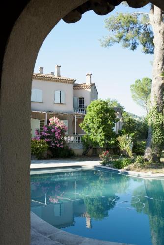 une piscine avec une maison en arrière-plan dans l'établissement Villa Grand Cèdre, à Marseille