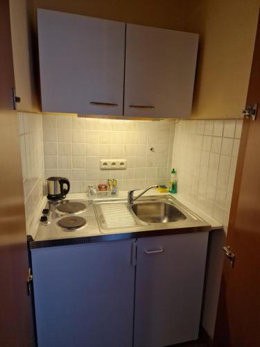 a small kitchen with a sink and a stove at City Hotel Hanseatic Bremen in Bremen