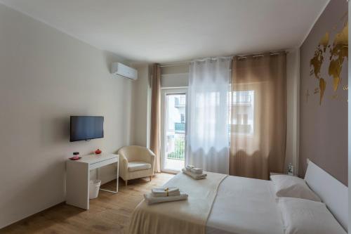 een witte slaapkamer met een bed en een raam bij H49 in Bari