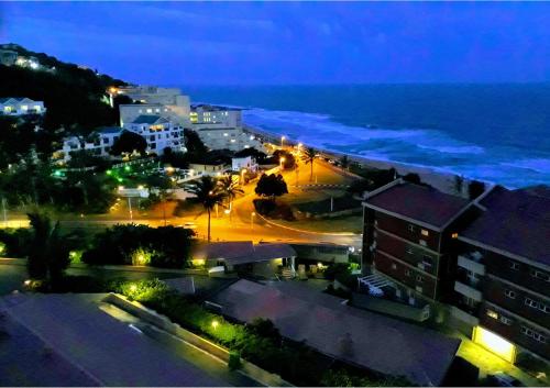 a view of a city at night with the ocean at Umdloti Holiday Resort Apartment 514 - Amazing Breaker & Ocean Views in Umdloti