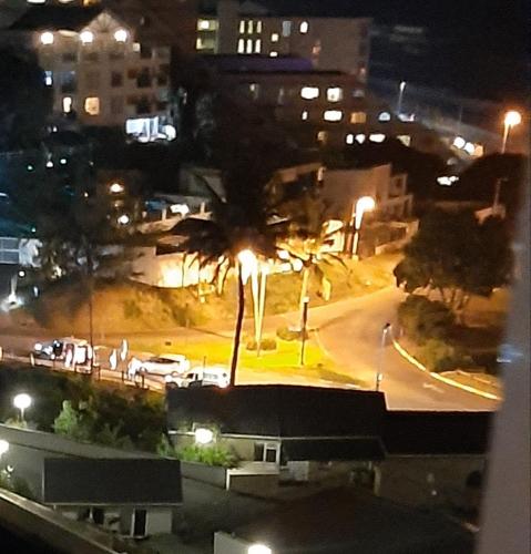 a city street at night with palm trees and buildings at Umdloti Holiday Resort Apartment 514 - Amazing Breaker & Ocean Views in Umdloti