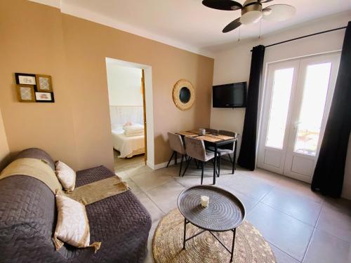 uma sala de estar com um sofá e uma mesa em Tiny Harmony - Logement confortable avec jardin et jacuzzi privés près d’Aix en Provence em Venelles