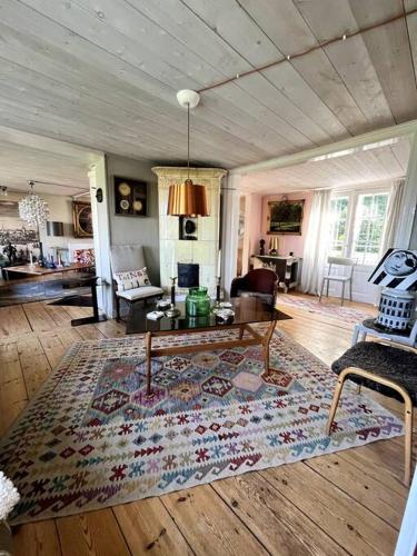 ein Wohnzimmer mit einem Teppich auf einem Holzboden in der Unterkunft Gränna Grandeur Stay in Style in Gränna