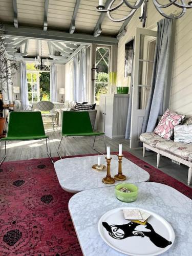a living room with two tables on a red rug at Gränna Grandeur Stay in Style in Gränna