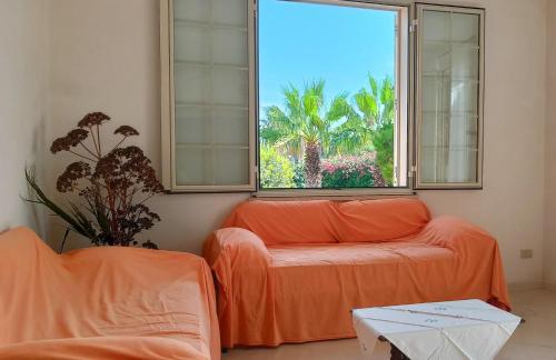 a living room with an orange couch and a window at VersoSUD in Marsala