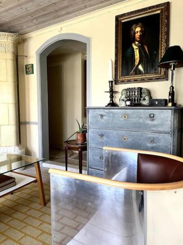a living room with a painting of a man on a dresser at Gränna Grandeur Stay in Style in Gränna