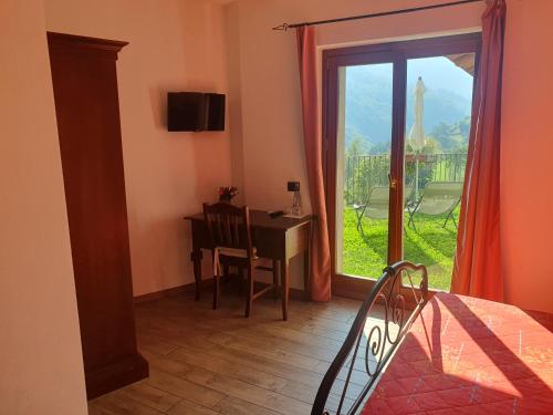 a bedroom with a desk and a window with a view at Agriturismo Nona Rosa in Gravedona