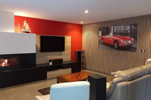 - un salon avec une voiture rouge sur le mur dans l'établissement chambre d'hote dans villa avec piscine, à Étival-lès-Le Mans