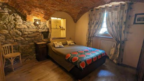 een slaapkamer met een bed in een kamer met een stenen muur bij Maison du Pont Romain in Aosta