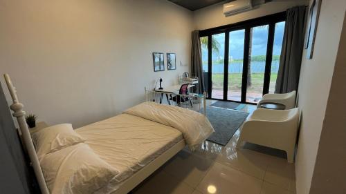 ein Schlafzimmer mit einem Bett und einem großen Fenster in der Unterkunft Jane and Hari Lakehouse in Puchong