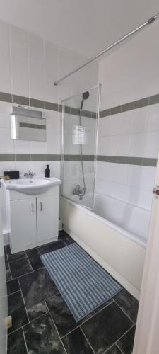uma casa de banho com uma banheira, um lavatório e um chuveiro em Cricklewood Broadway Guest Home em Londres