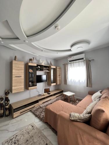 GRACELAND new apartment in Hurghada center في الغردقة: غرفة معيشة مع أريكة وتلفزيون