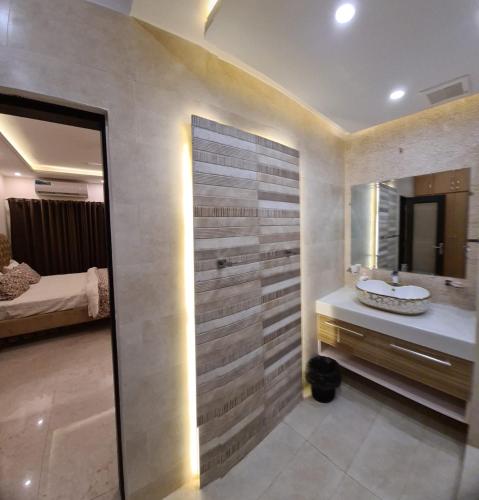a bathroom with a sink and a mirror at Haven Lodge - 7BR Luxury Vacation Home with Mountain View in Islamabad