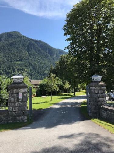 a gate on a road with a mountain in the background at Chalet-Stil mit Pool und Bergblick in Sankt Martin bei Lofer