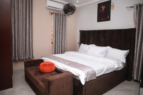 a bedroom with a large bed with a brown headboard at Newly Built 2 Bedroom Tastefully Furnished House Available For Shortlet. in Lagos